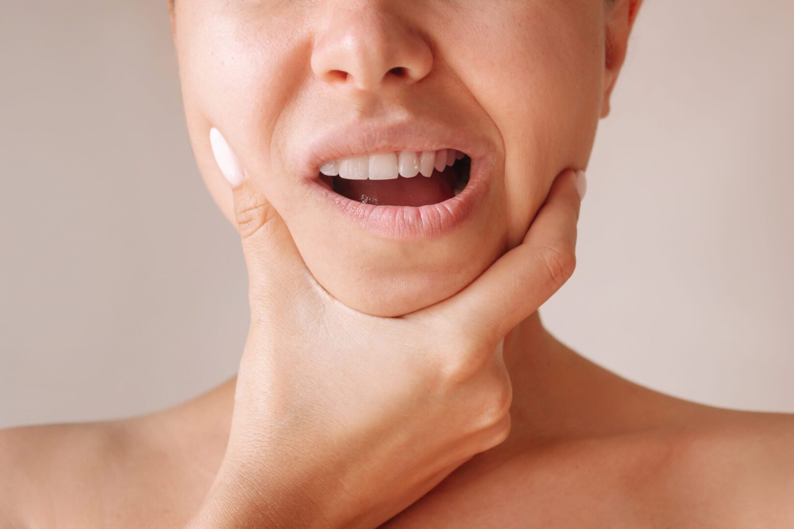 Cropped shot of a young woman suffering from jaw pain holding he can a chiropractor help with TMJD